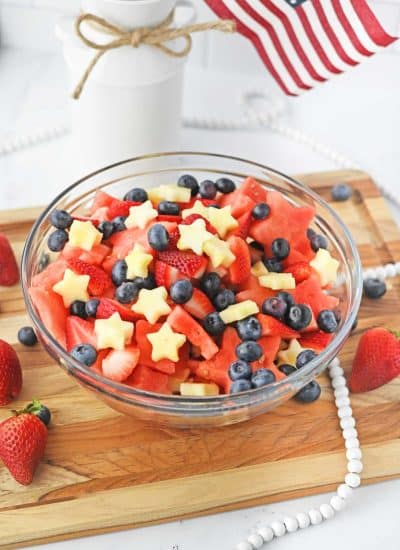 star-shaped fruit with strawberries and blueberries in glass bowl
