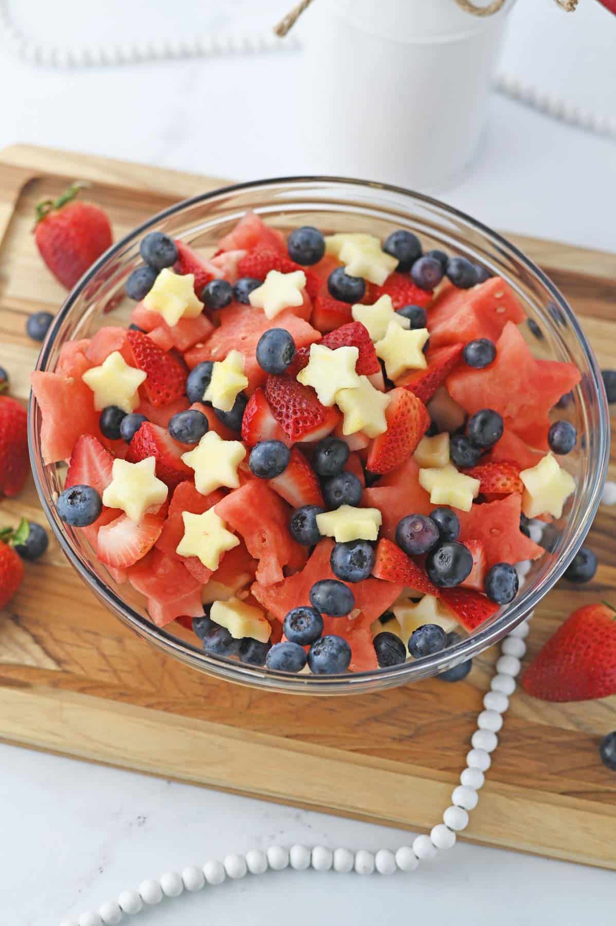 star-shaped watermelon, strawberries, and blueberries in glas sbowl