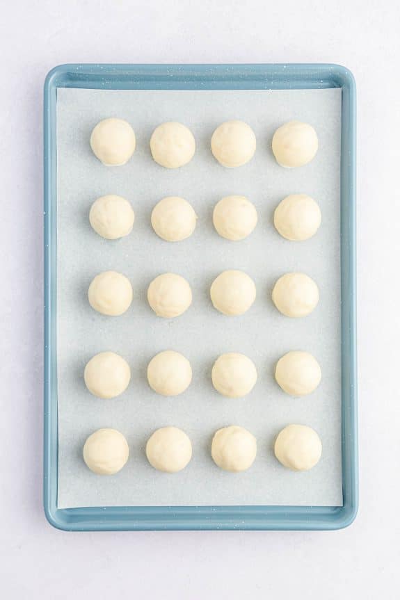 white chocolate coated cake balls in rows on baking sheet