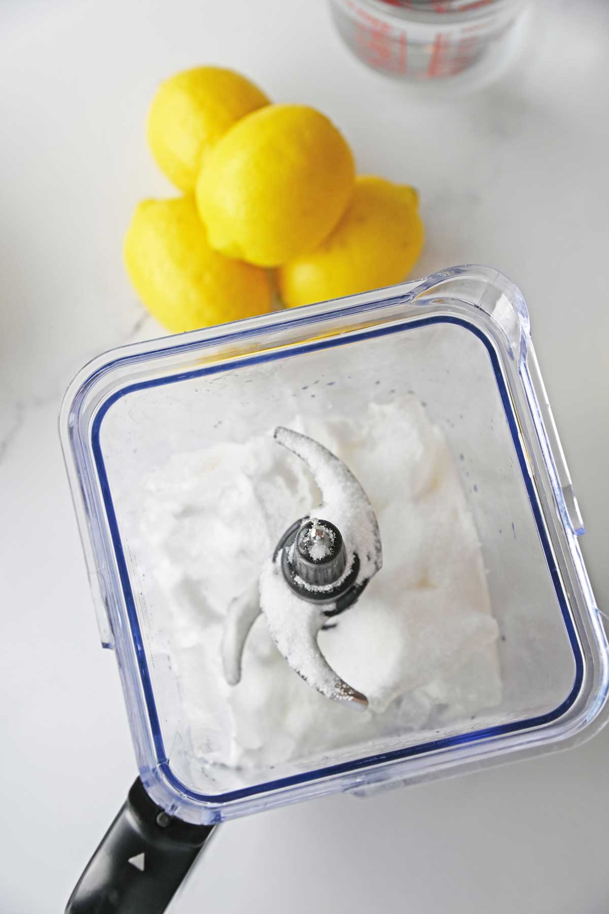 Next process in preparing Lemonade Slushie is to add a granulated sugar.