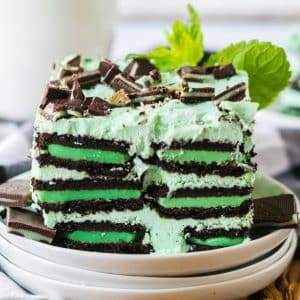 green filled oreo cookies stacked in an ice box cake with mint green icing