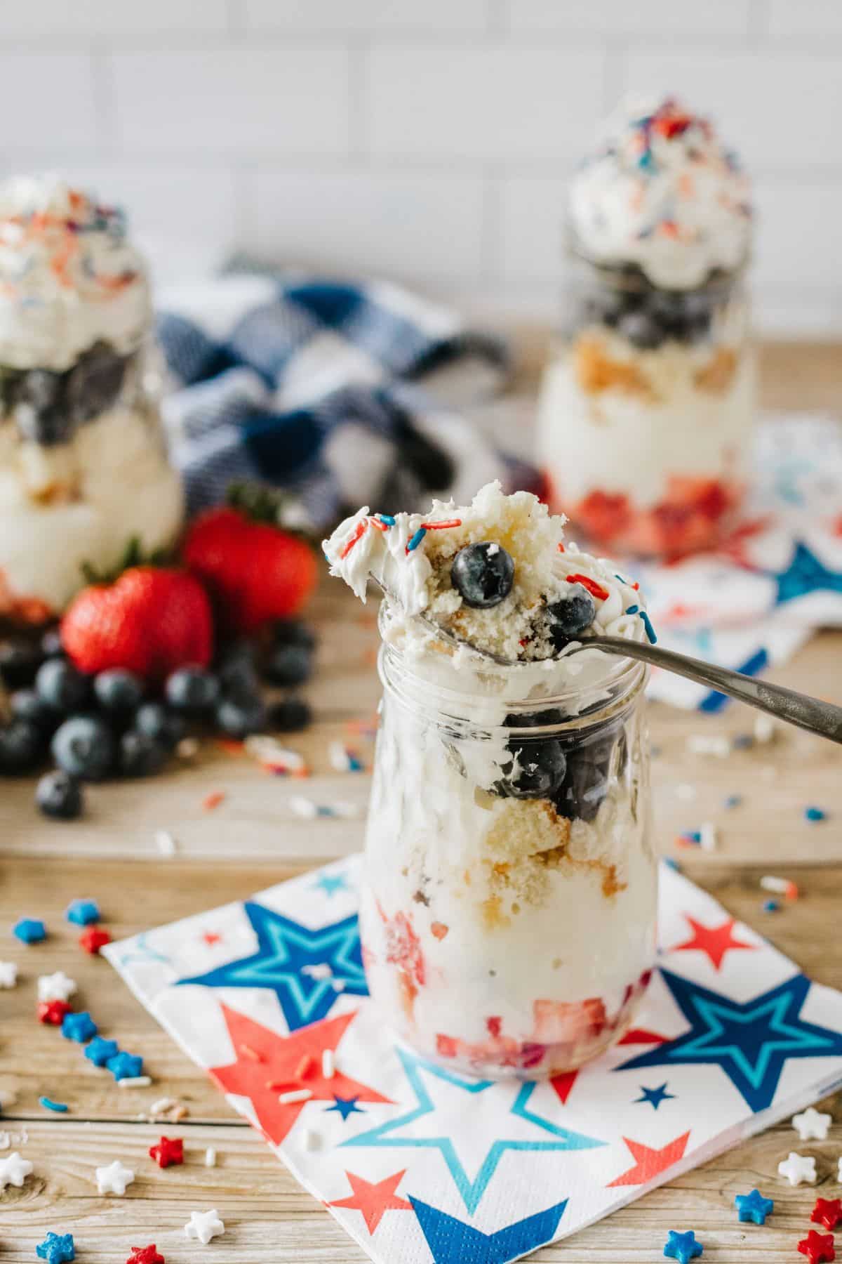 spoon with cake and berries on it from mason jar