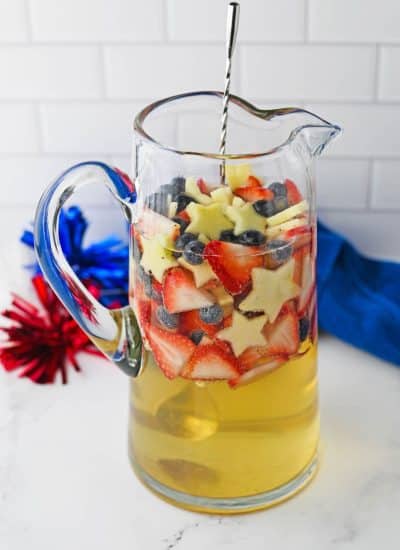 large glass pitcher with white sandria topped with red white and blue fruit
