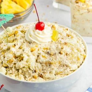 pineapple fluff in white bowl with cherry on top