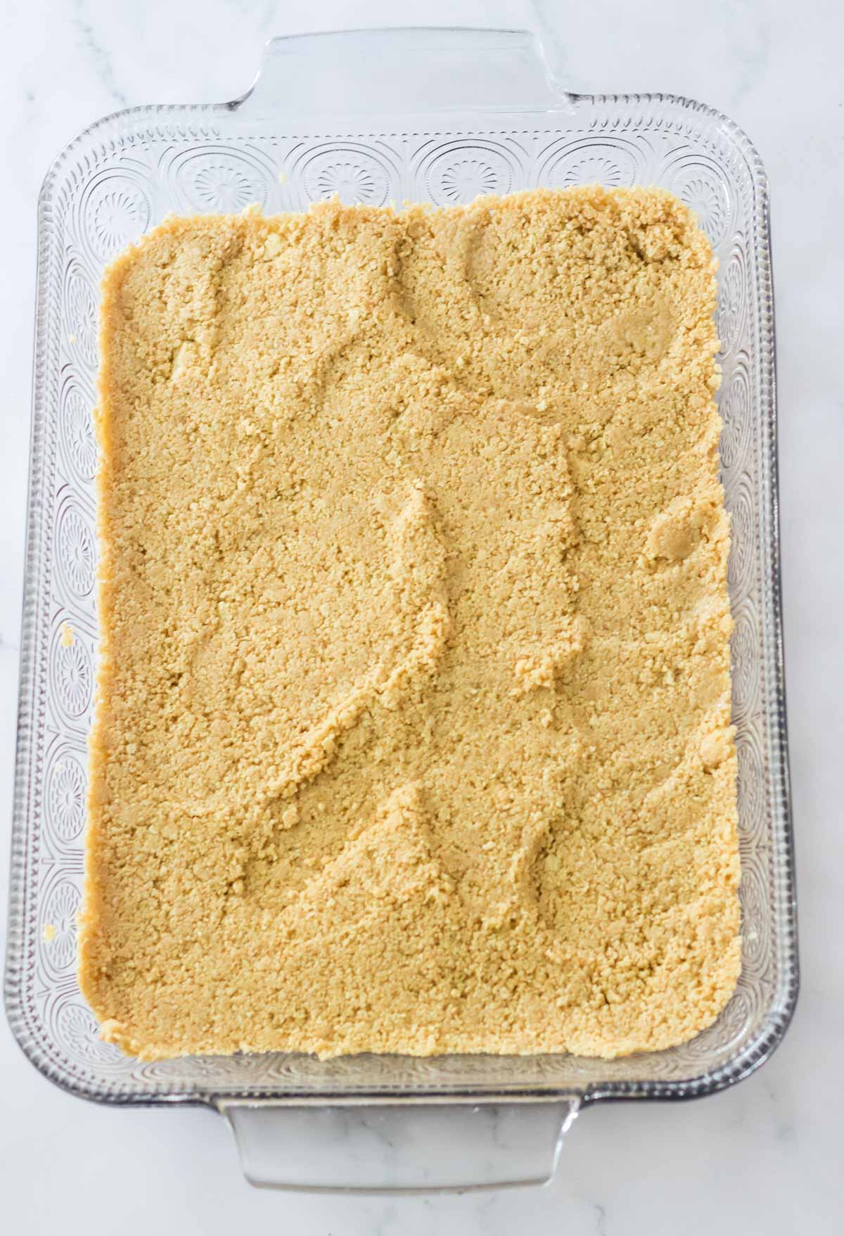 graham cracker crust in bottom of glass pan