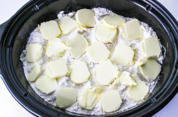 tabs of butter on top of cake mix in crockpot