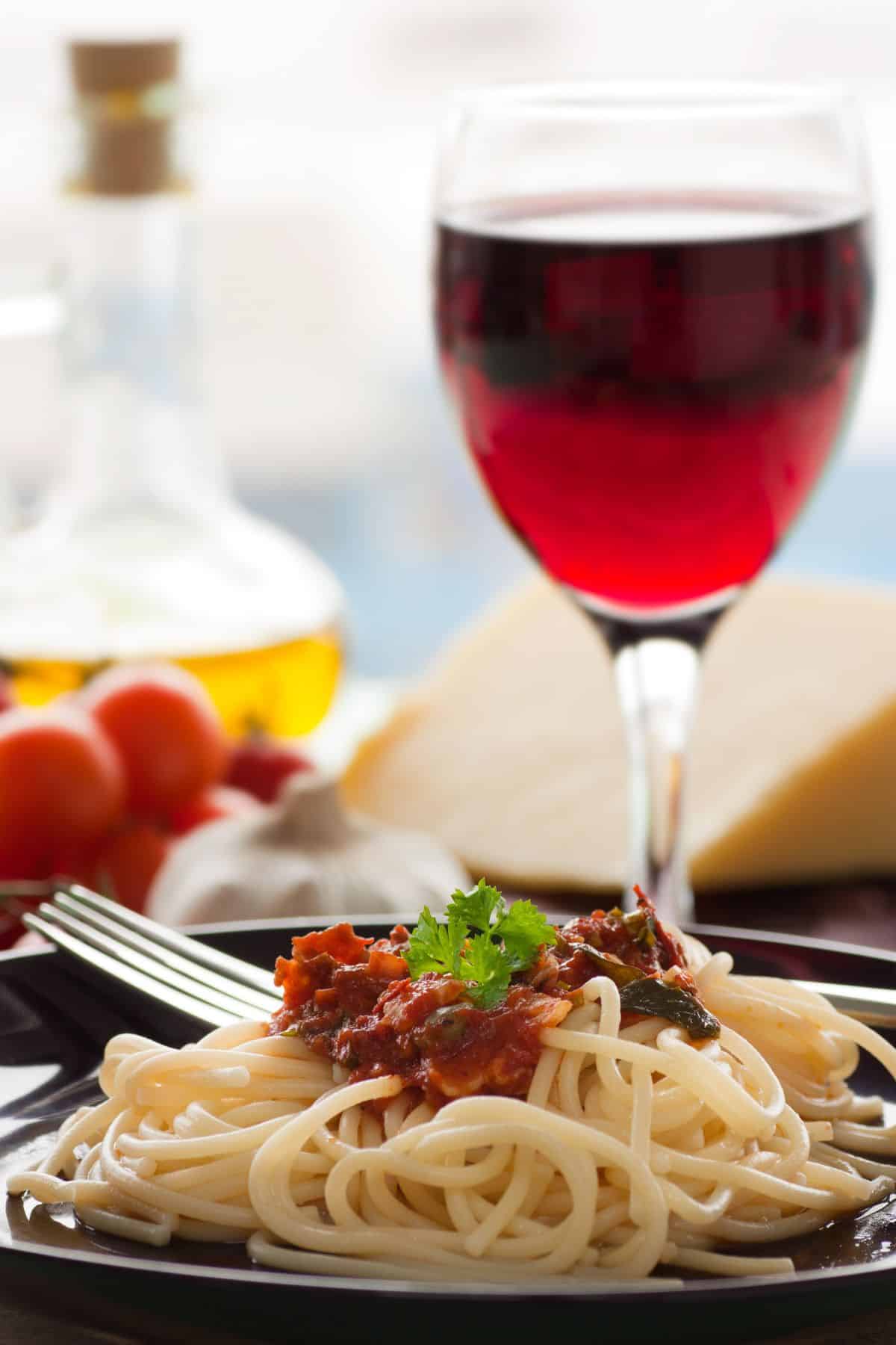 red wine in glass with plate of spaghetti