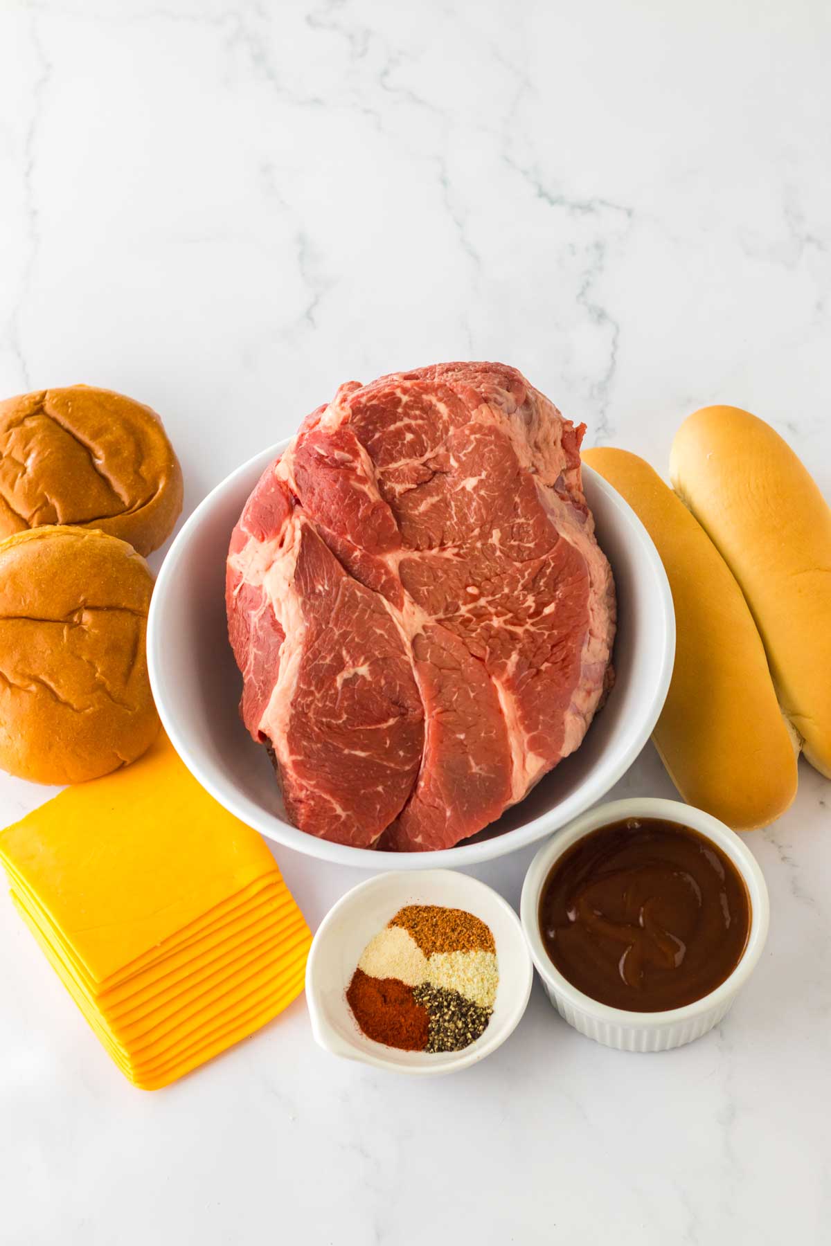 Ingredients for Slow Cooker BBQ Beef Sandwiches are the following: beef roast, onion powder, garlic salt (or garlic powder), black pepper, smoked paprika, cajun seasoning, BBQ sauce, buns and cheddar cheese, optional