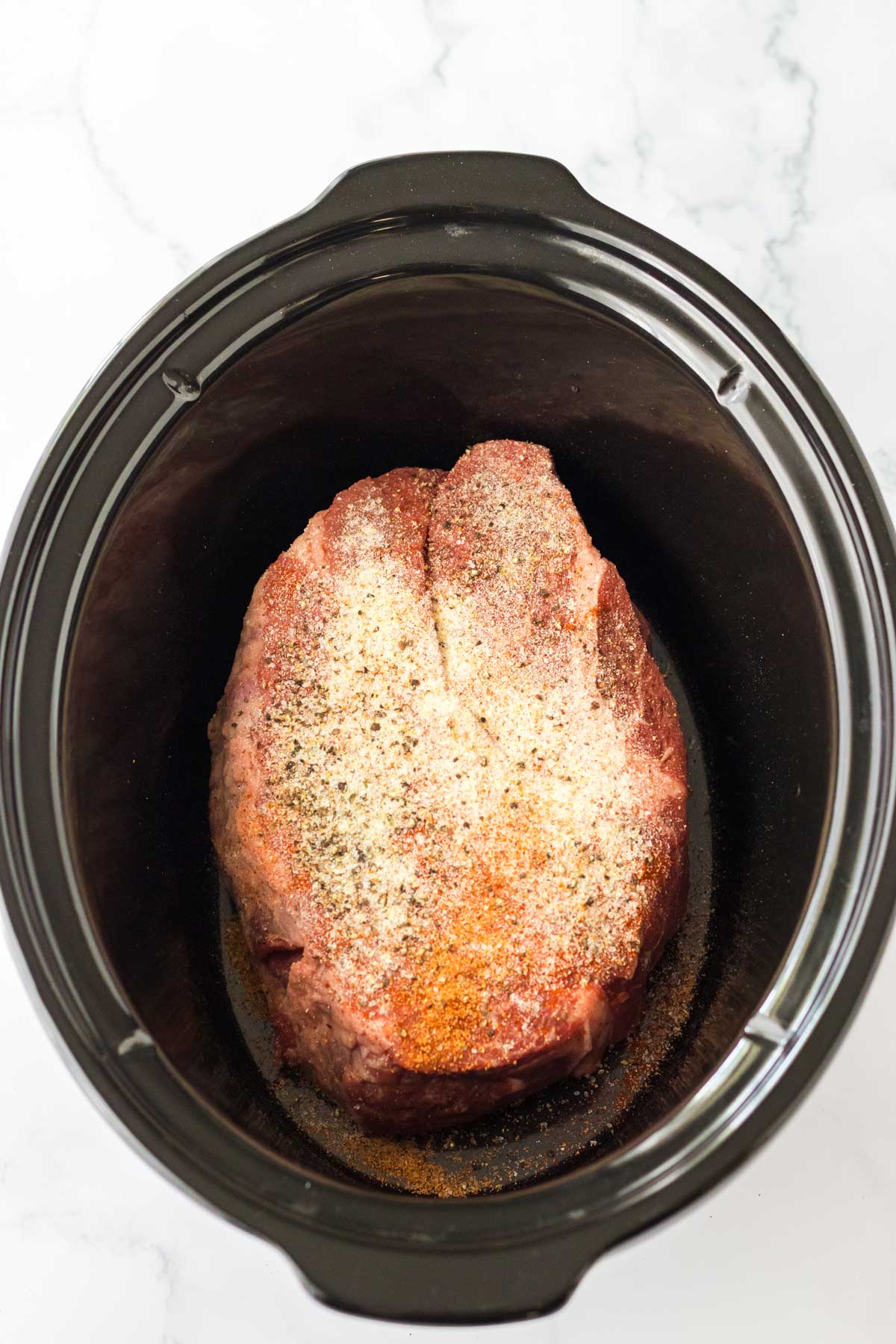 Seasoning the meat for Slow Cooker BBQ Beef Sandwiches