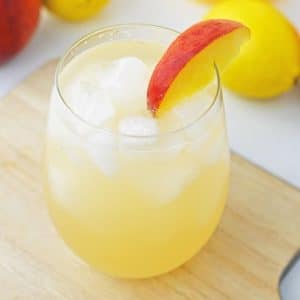 peach lemonade in glass with peach slice