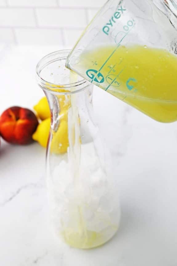 pouring lemon juice into pitcher