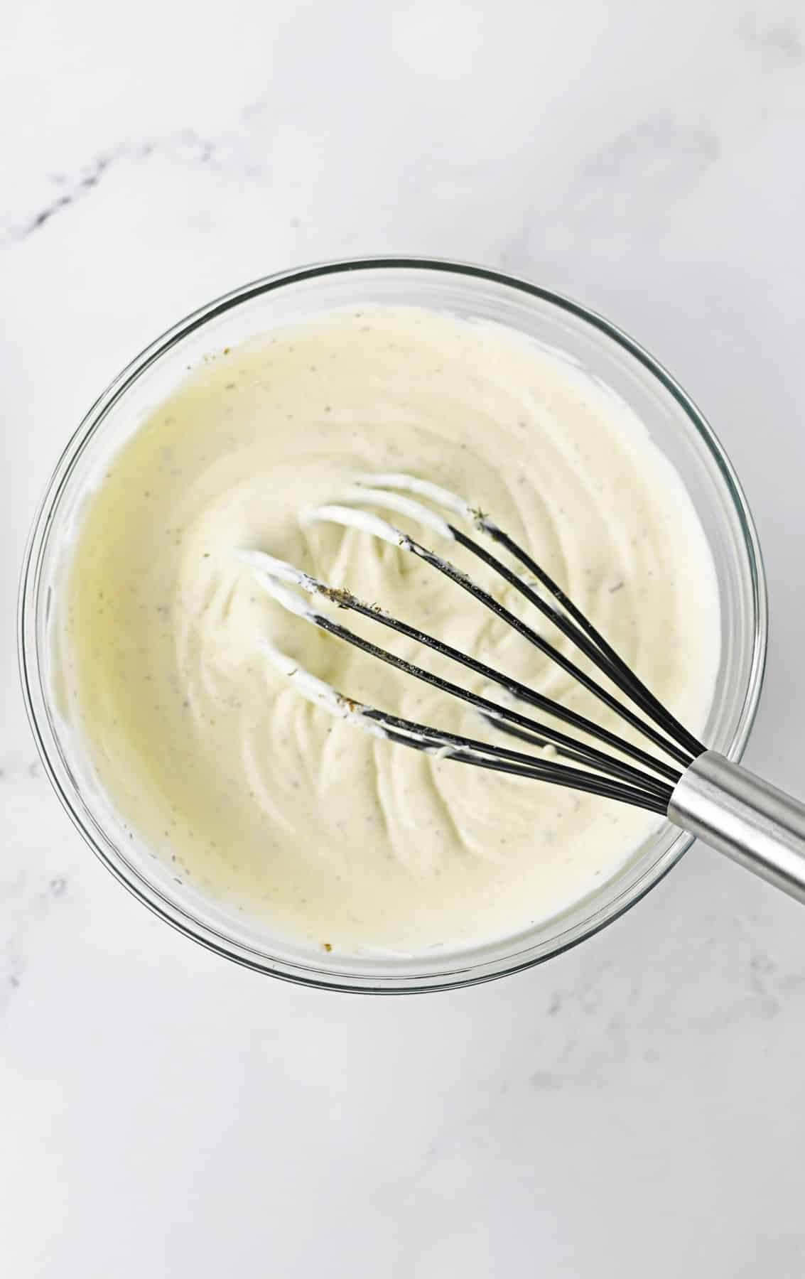 mayonnaise mixture in glass bowl with whisk