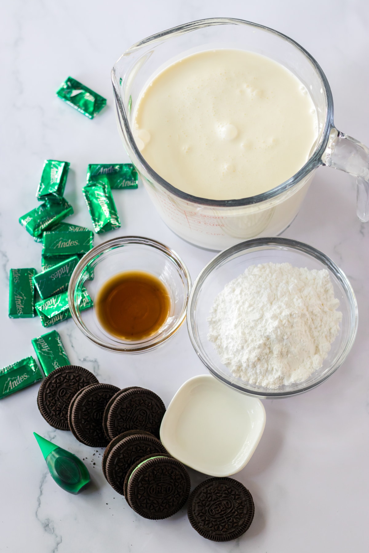 Ingredients for Mint Chocolate Icebox Cake include Mint Oreo cookies, heavy whipping cream, powdered sugar, pure vanilla extract, mint extract, green food coloring, and Andes mints for toppings.