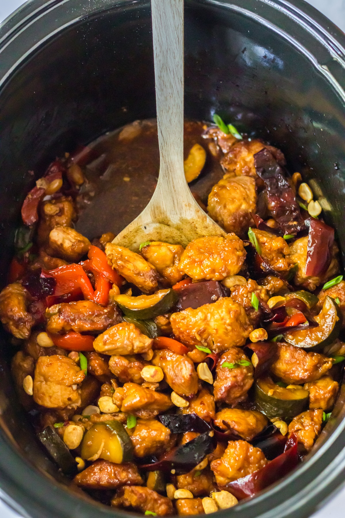 A scoop of Slow Cooker Kung Pao Chicken in a pot