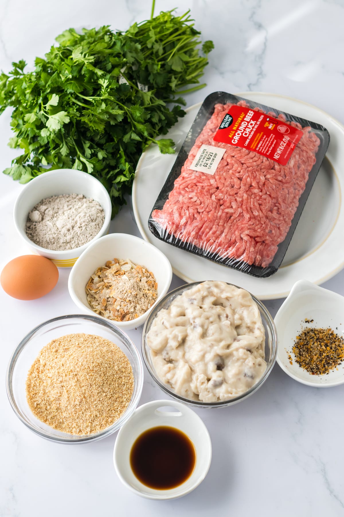 Ingredients for Slow Cooker Smothered Hamburgers include lean ground beef, dry onion soup mix, worcestershire sauce, steak seasoning, egg, bread crumbs, cream of mushroom soup, water, brown gravy mix and parsley for garnish, optional