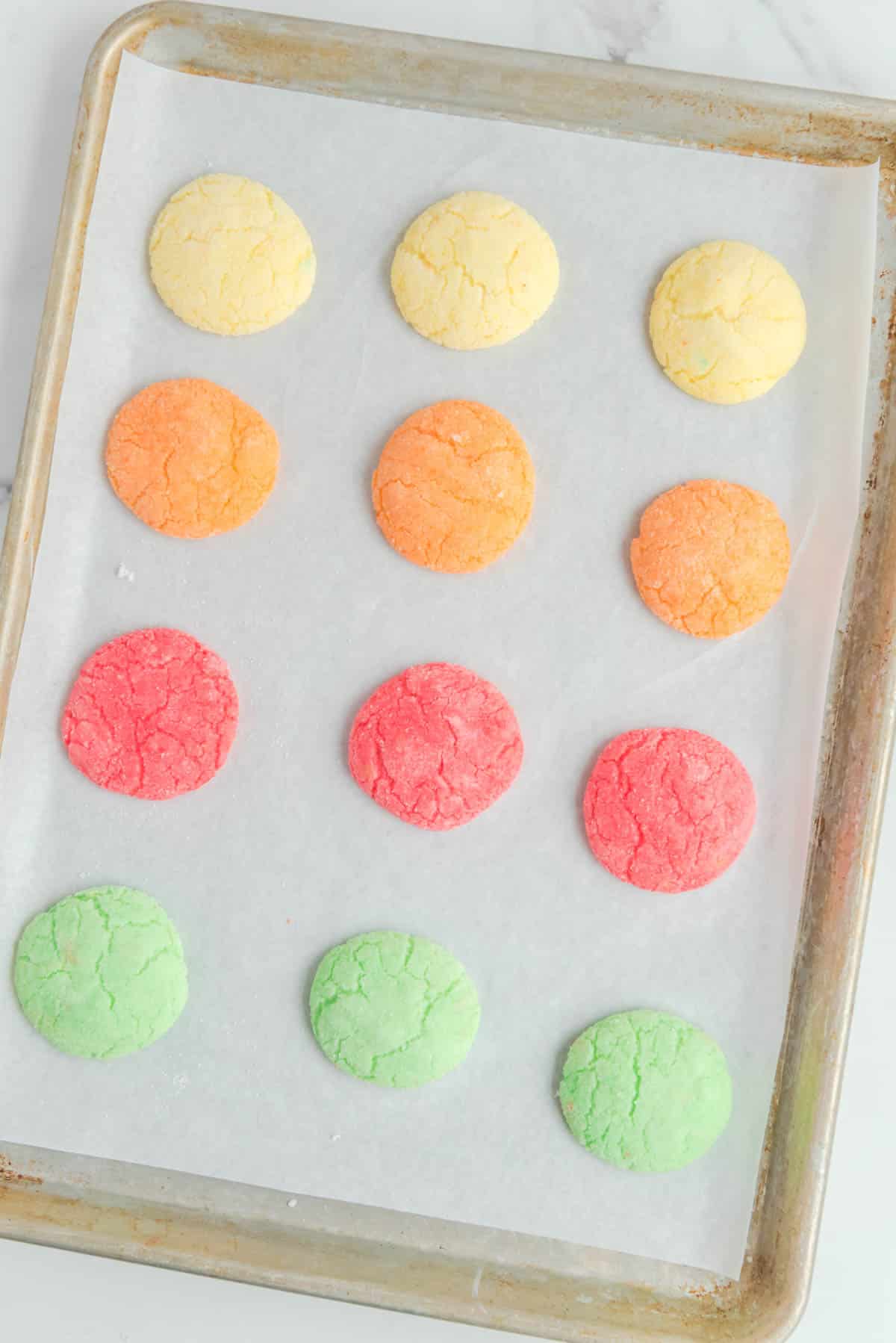 yellow orang red and green cookies on baking sheet