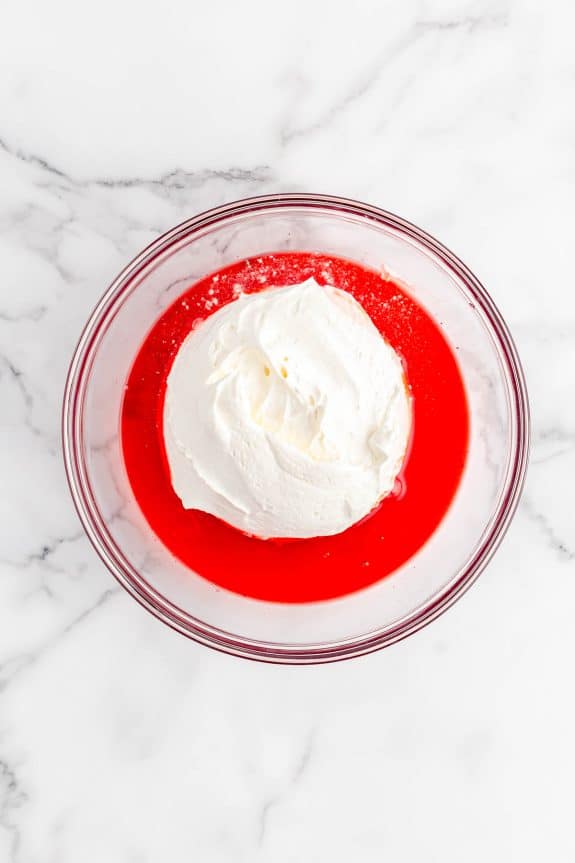 red mixture with whipped cream in middle in glass bowl