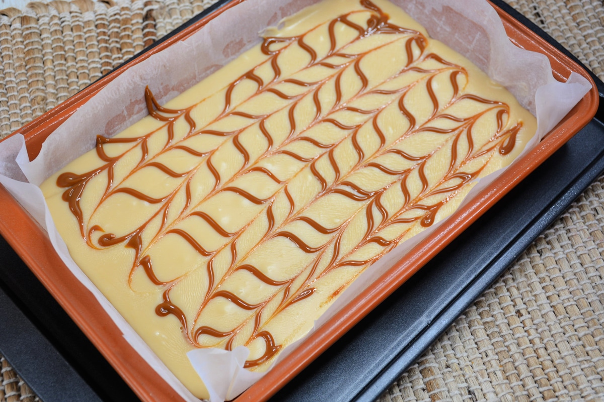 Last step in preparing Dulce de Leche Fudge is to pour the remaining Dulce de Leche in a pan and create a pretty design with it.
