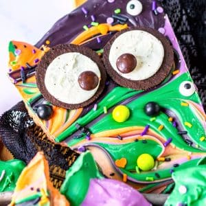 A festive Halloween bark adorned with a rich chocolate coating and an assortment of sweet candies.