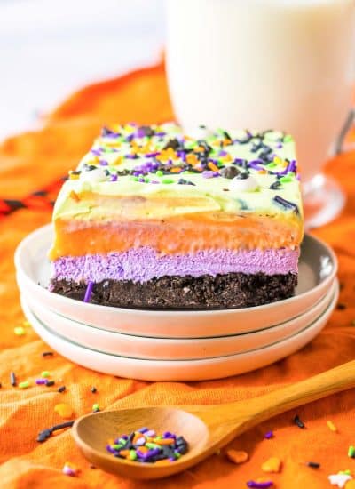 A plate with a rainbow layered dessert on it.