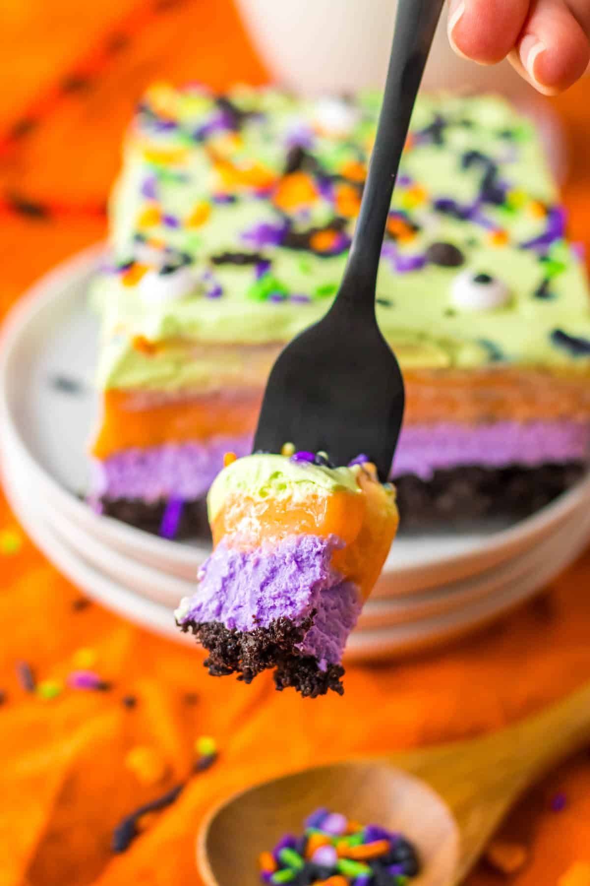 A person is taking a bite out of a halloween ice cream cake.