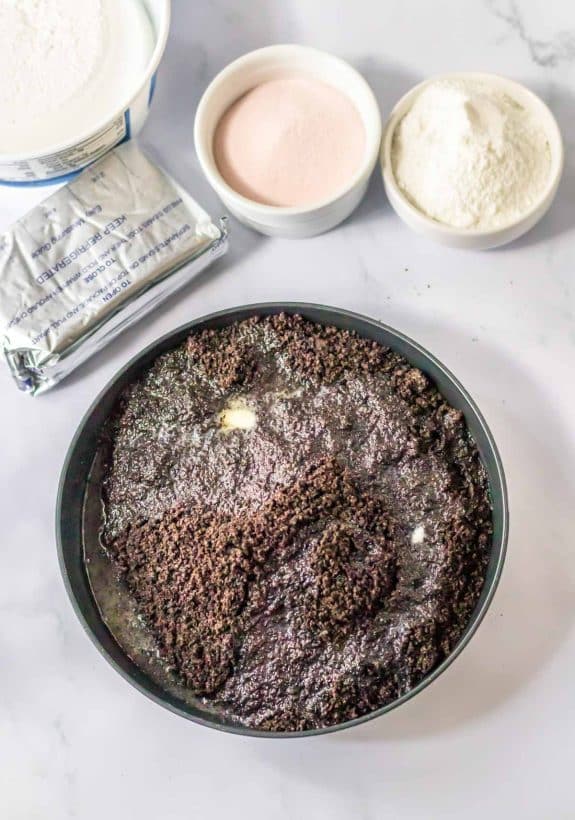 Ingredients for a chocolate cake in a pan on a marble table.
