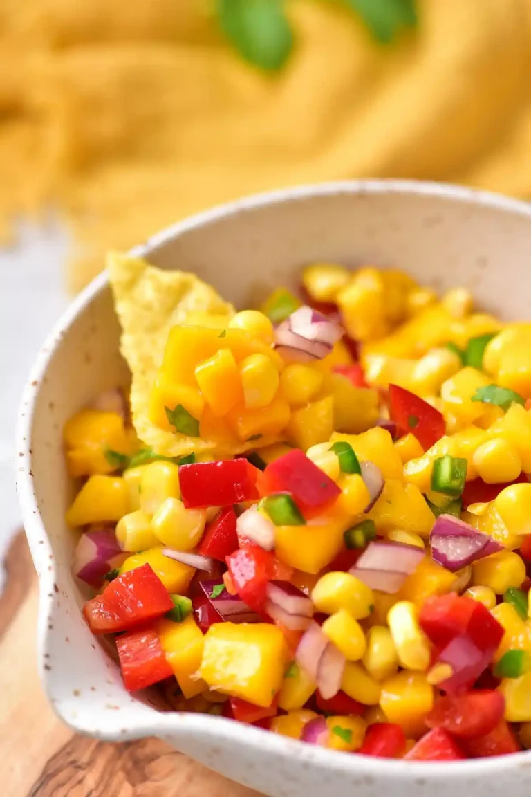 Mango salsa in a white bowl with tortilla chips.