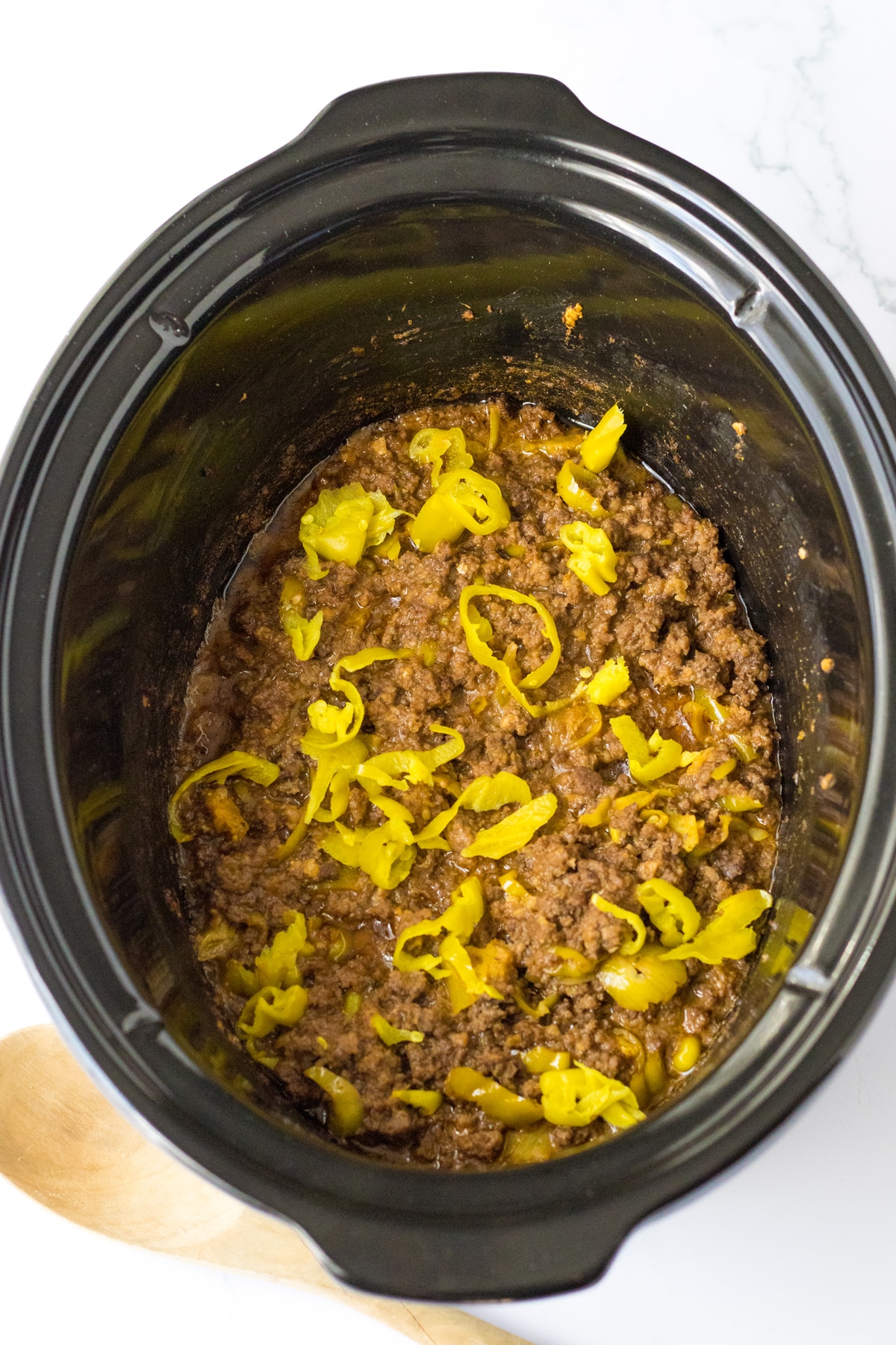 Next process in preparing is to mix Slow Cooker Mississippi Sloppy Joes in a crock pot filled with Sliced pepperoncini peppers and ground beef