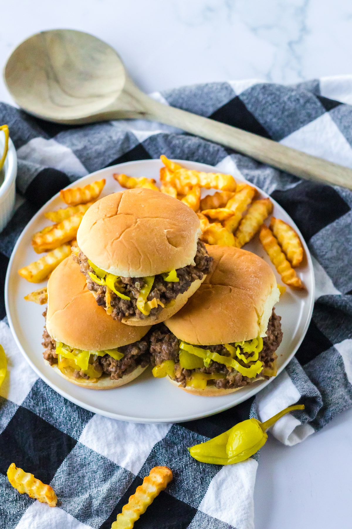 Slow Cooker Mississippi Sloppy Joes on a plate with fries and ketchup.