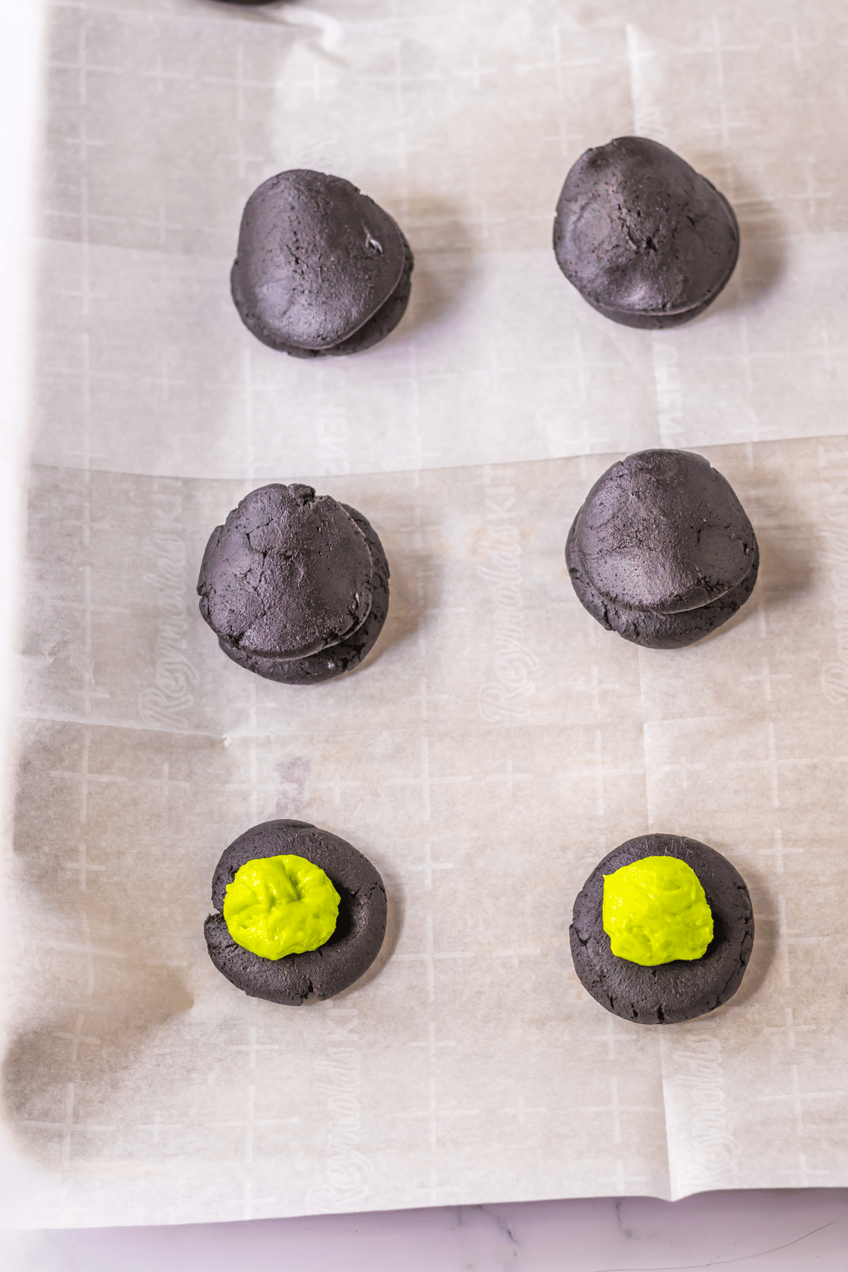 Another process in making Halloween Black Velvet Cookies is to scoop the mixture and form it into balls. Place them on parchment.