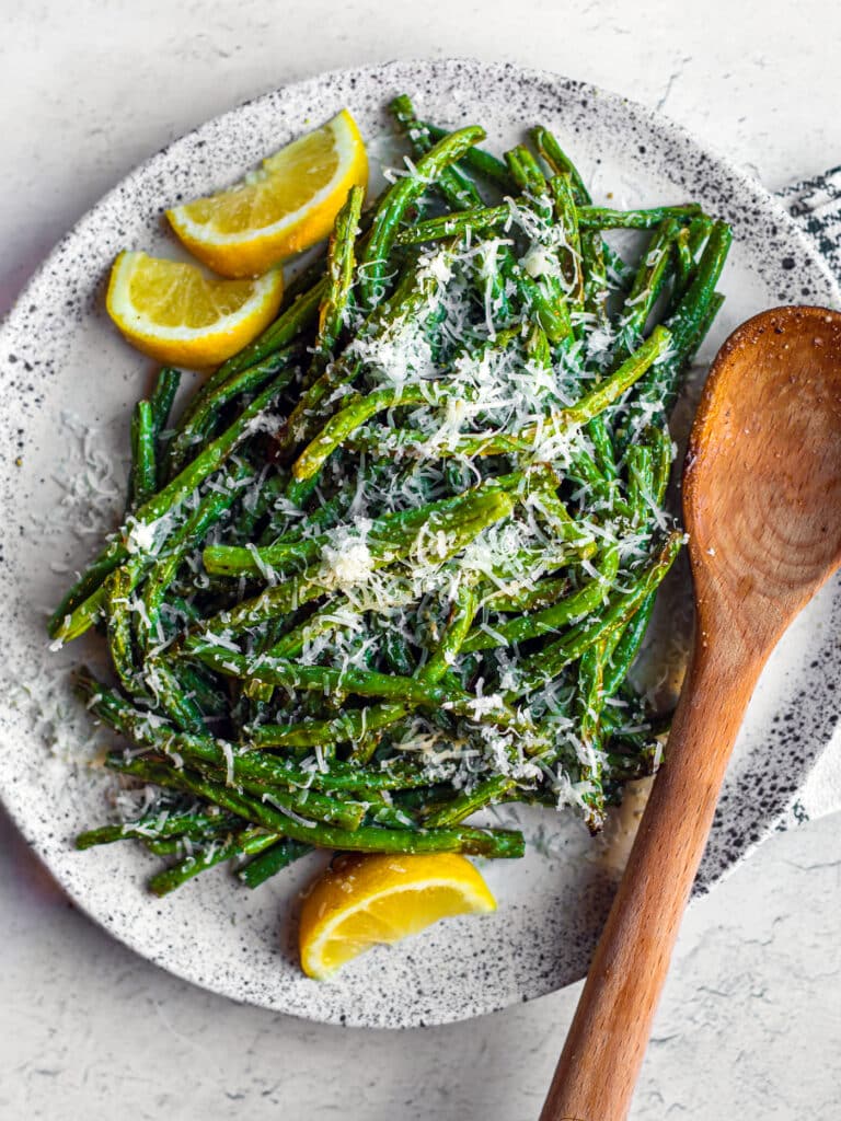 Green beans with parmesan and lemon on a plate.