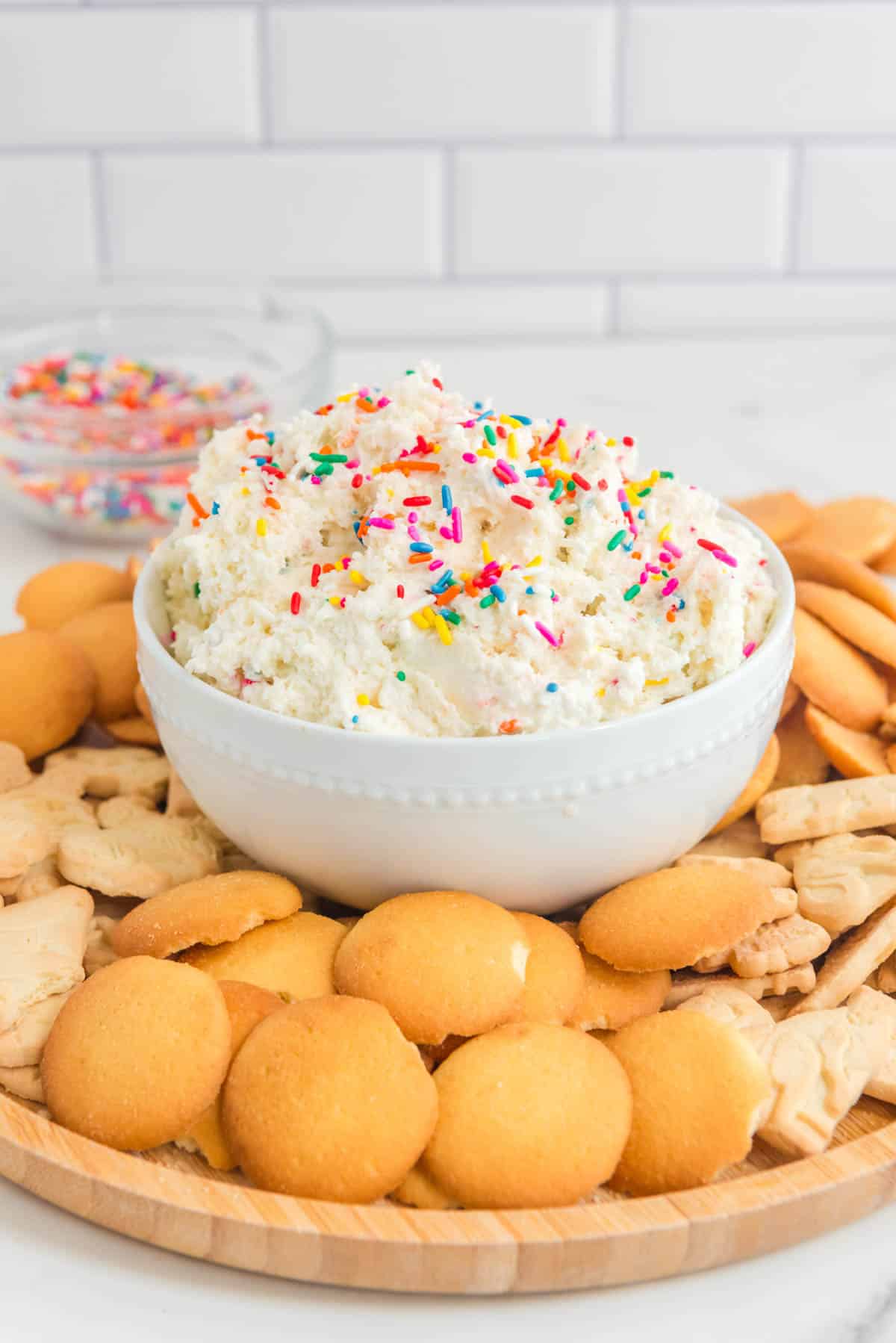 A bowl of dip with sprinkles and crackers.