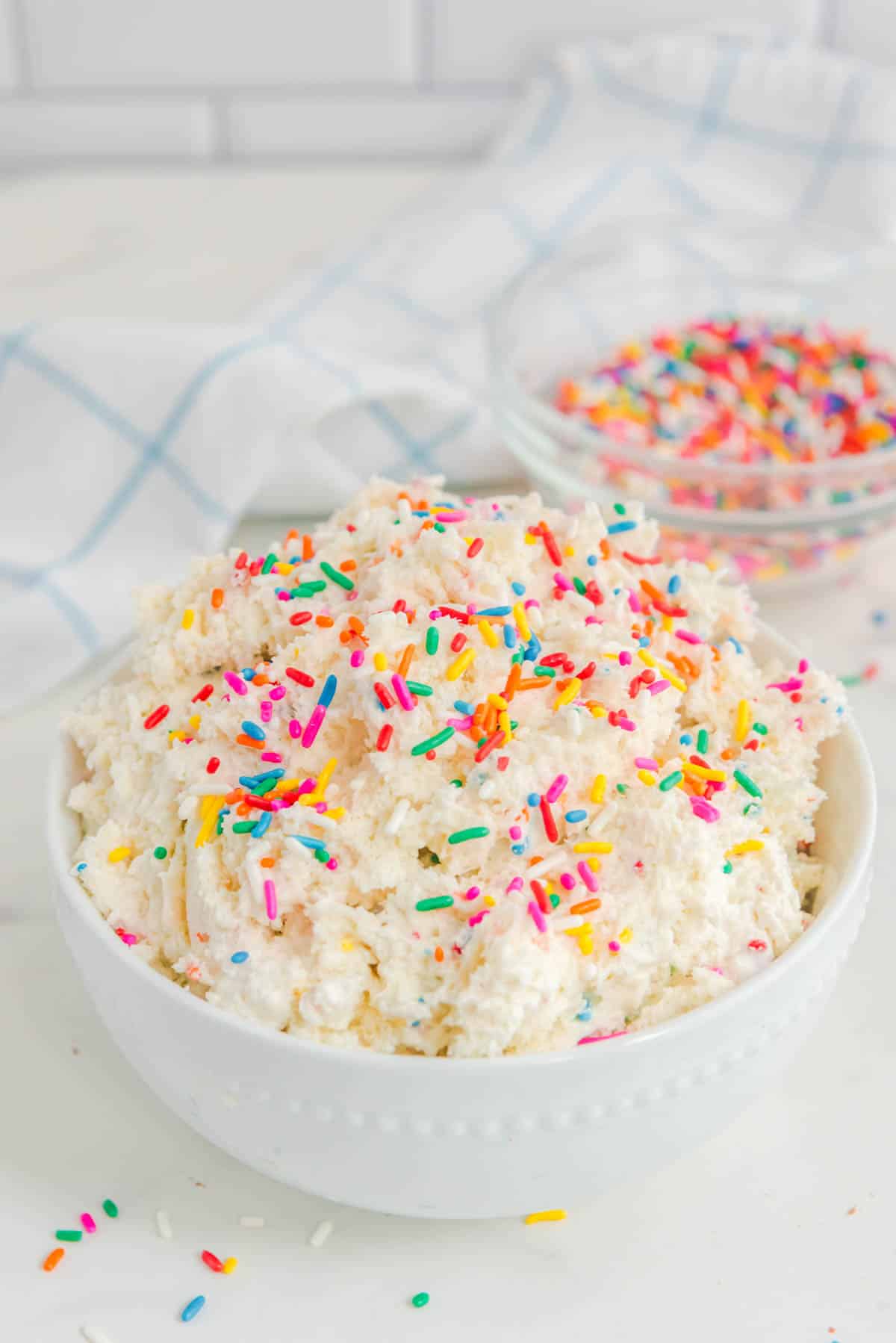 A bowl of icing with sprinkles in it.