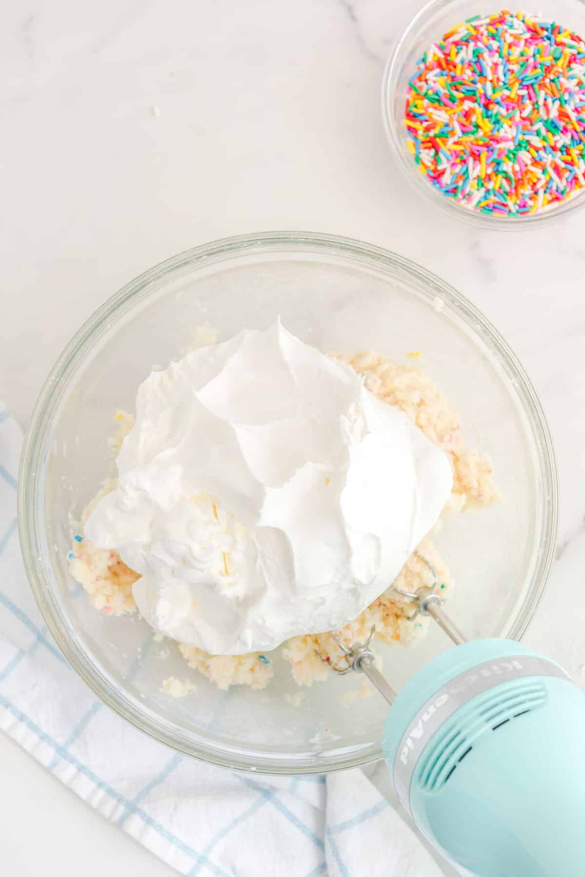 A bowl full of whipped cream and sprinkles.
