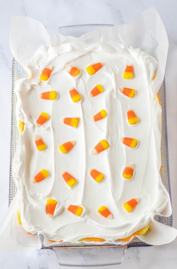 A white cake with candy corn on top.