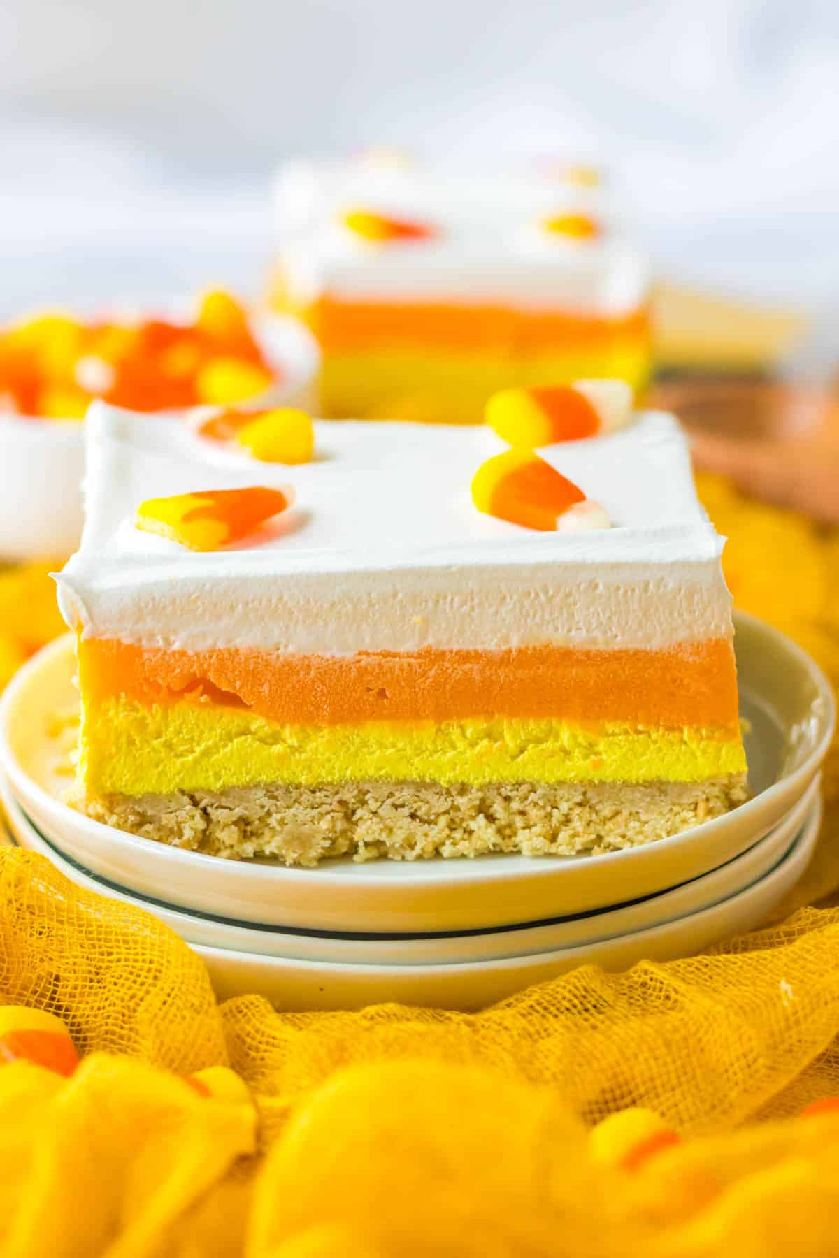 A slice of candy corn cheesecake on a plate.