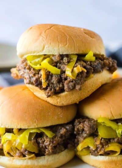 Buns filled with sloppy joe mixture stacked on top of each other.