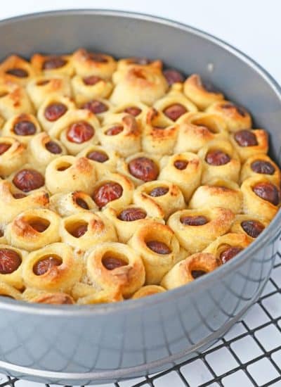 A pan filled with a dough filled with hot dogs.