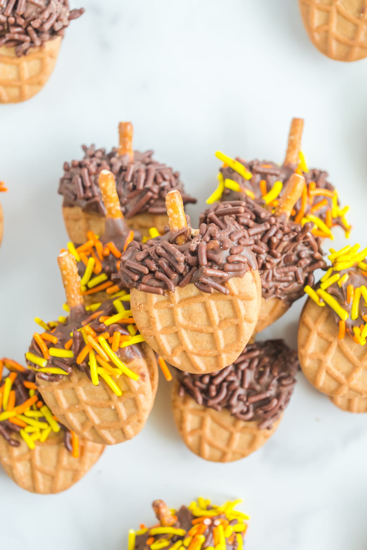 A group of Nutter Butter Acorns with chocolate sprinkles on top.