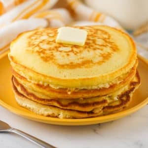 A stack of pancakes using Homemade Pancake Mix on a yellow plate with butter.