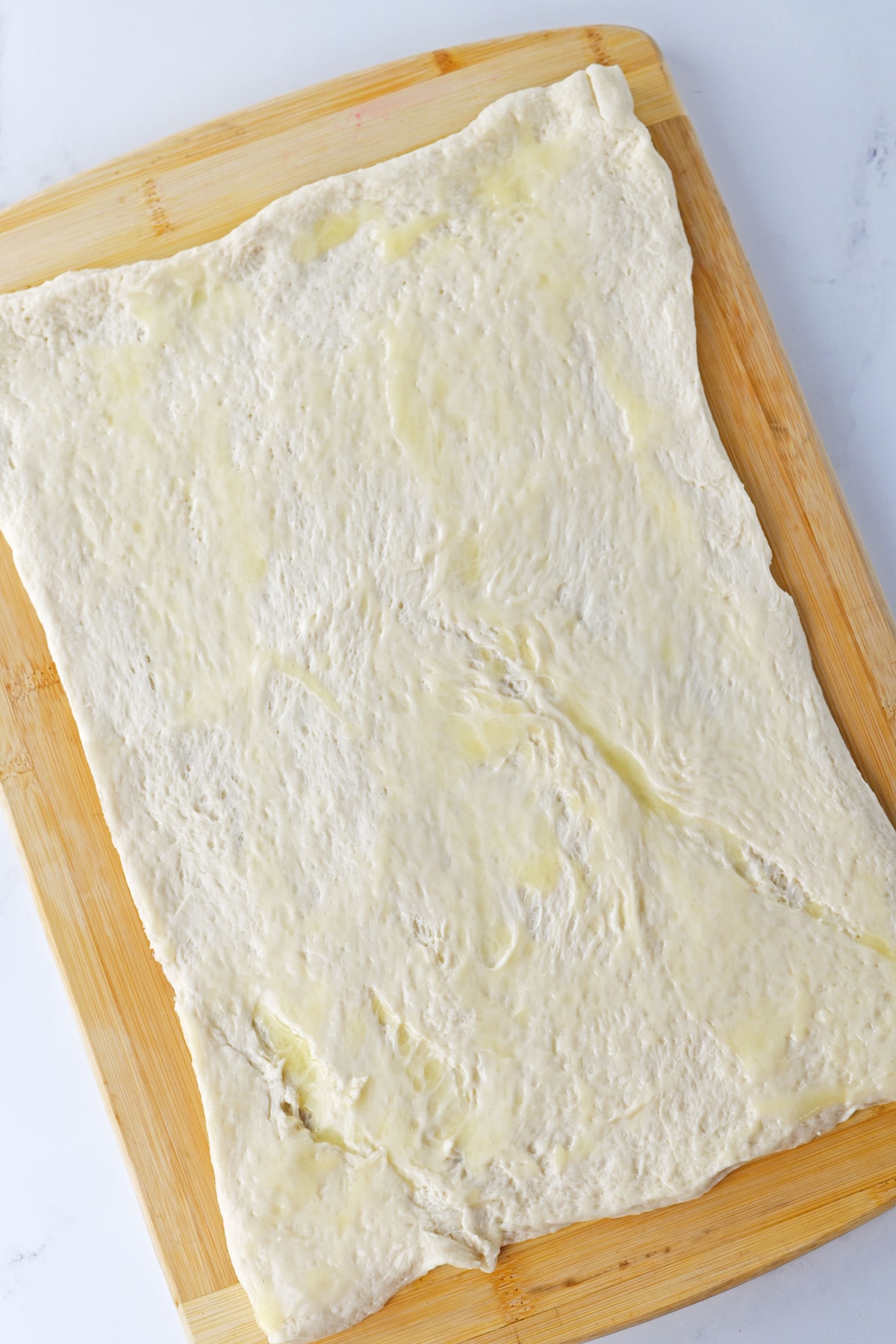 A piece of dough on a cutting board.