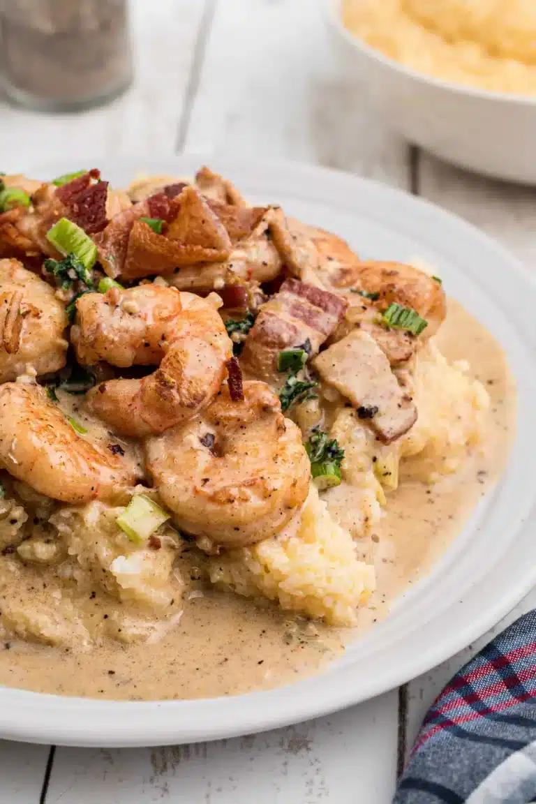 Shrimp and grits on a plate with gravy.