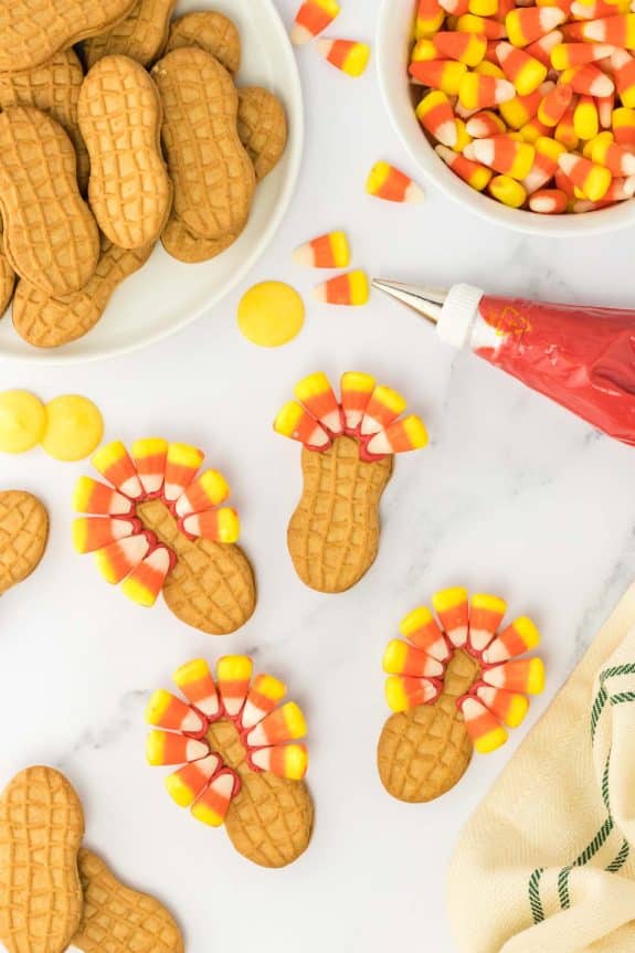 Thanksgiving cookies with candy corn and peanuts on a white table.