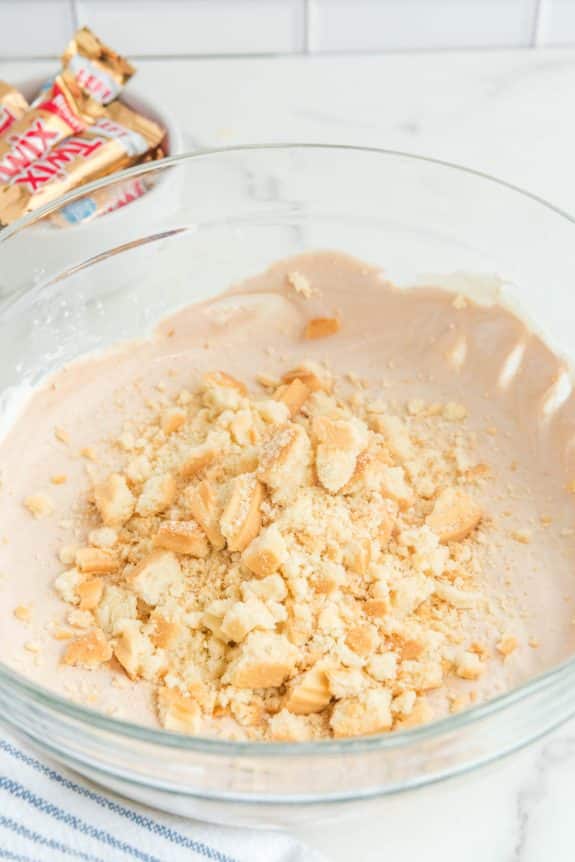 A glass bowl filled with a mixture of graham cracker crumbs.
