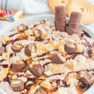 A bowl filled with Twix dessert and ice cream.