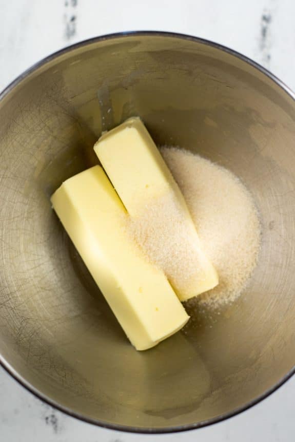 Two pieces of butter in a metal mixing bowl.