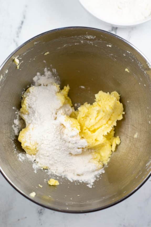 A mixing bowl with flour, eggs, and butter.