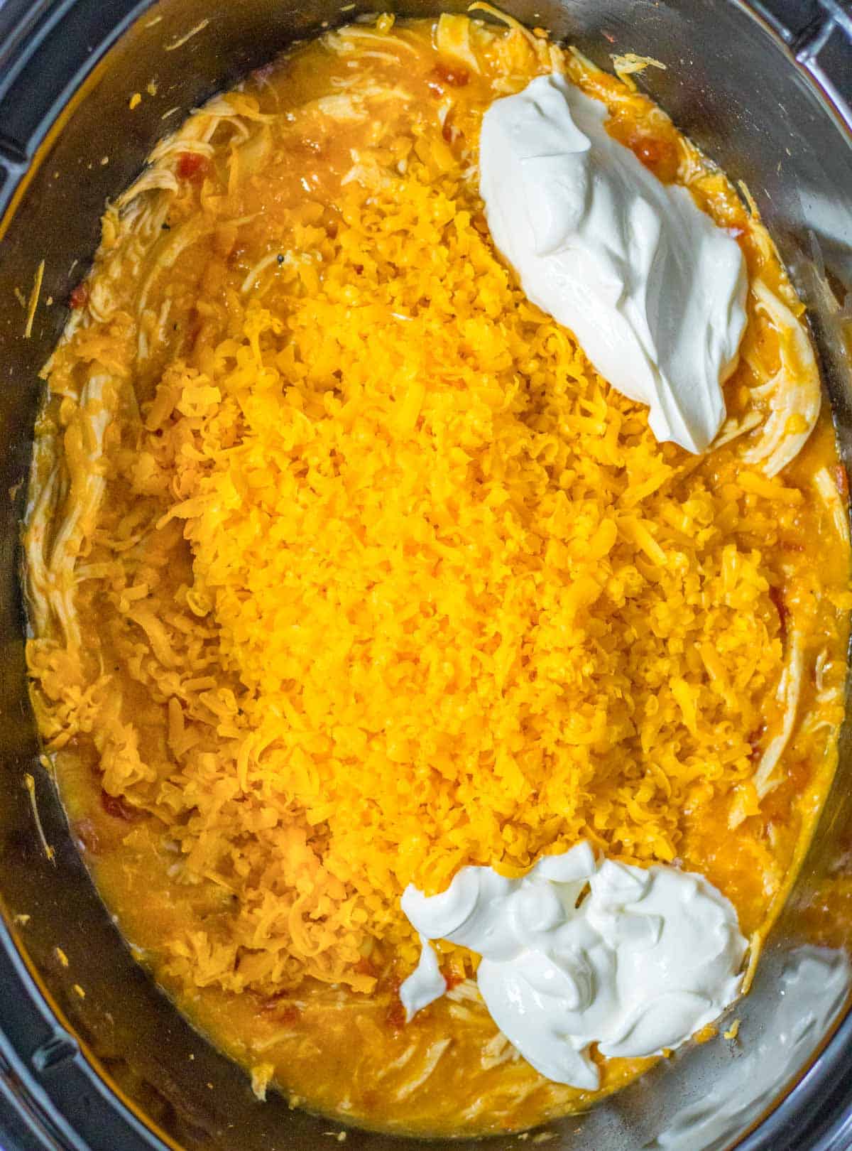 A crock pot filled with rice and sour cream.