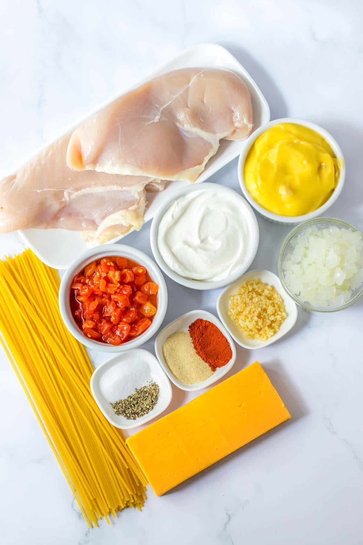 Ingredients for chicken parmigiana on a white background.