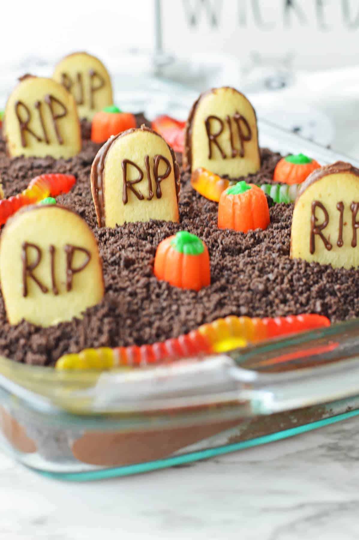 A halloween graveyard cake in a glass dish.